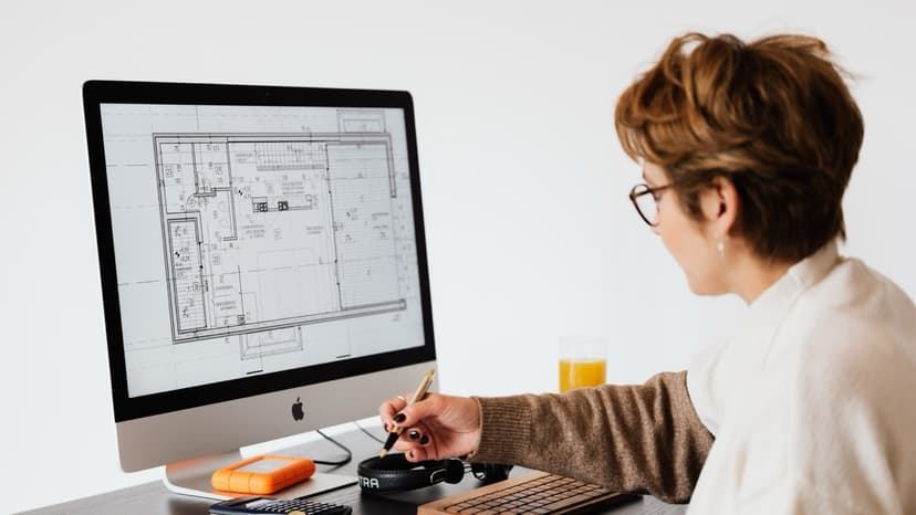 Estimator reviewing floor plans on desktop computer