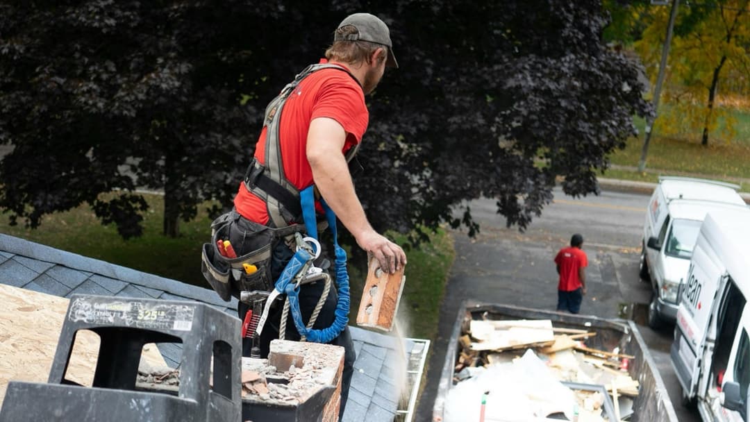 Roofer carrying materials on a residential job site